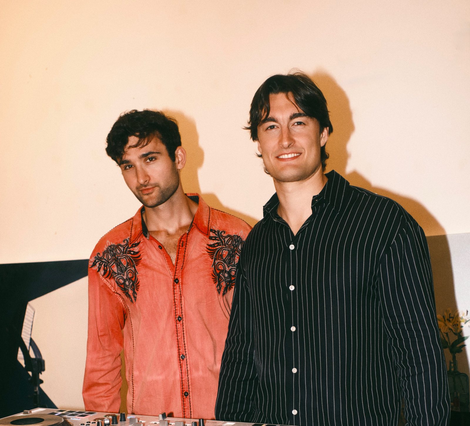 The two members of PREWAR standing behind DJ decks
